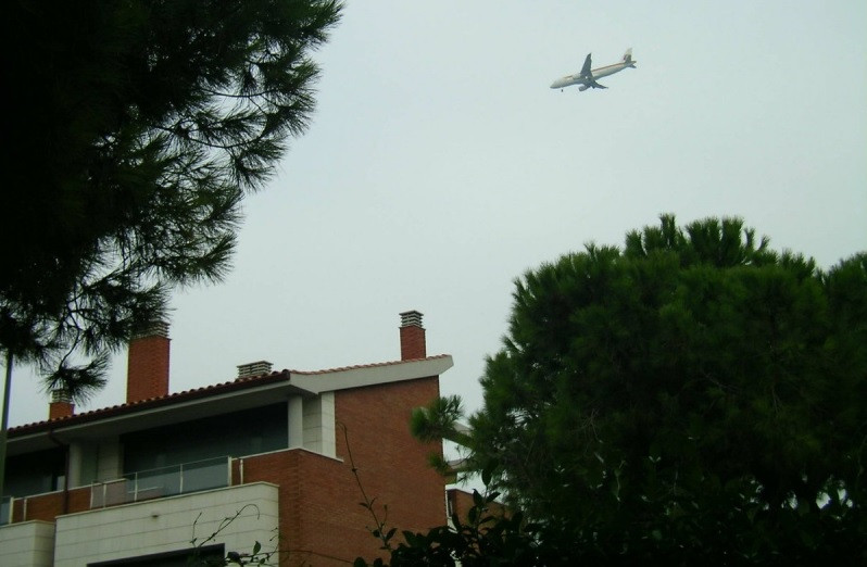 Avión sobrevolando por encima de las casas.